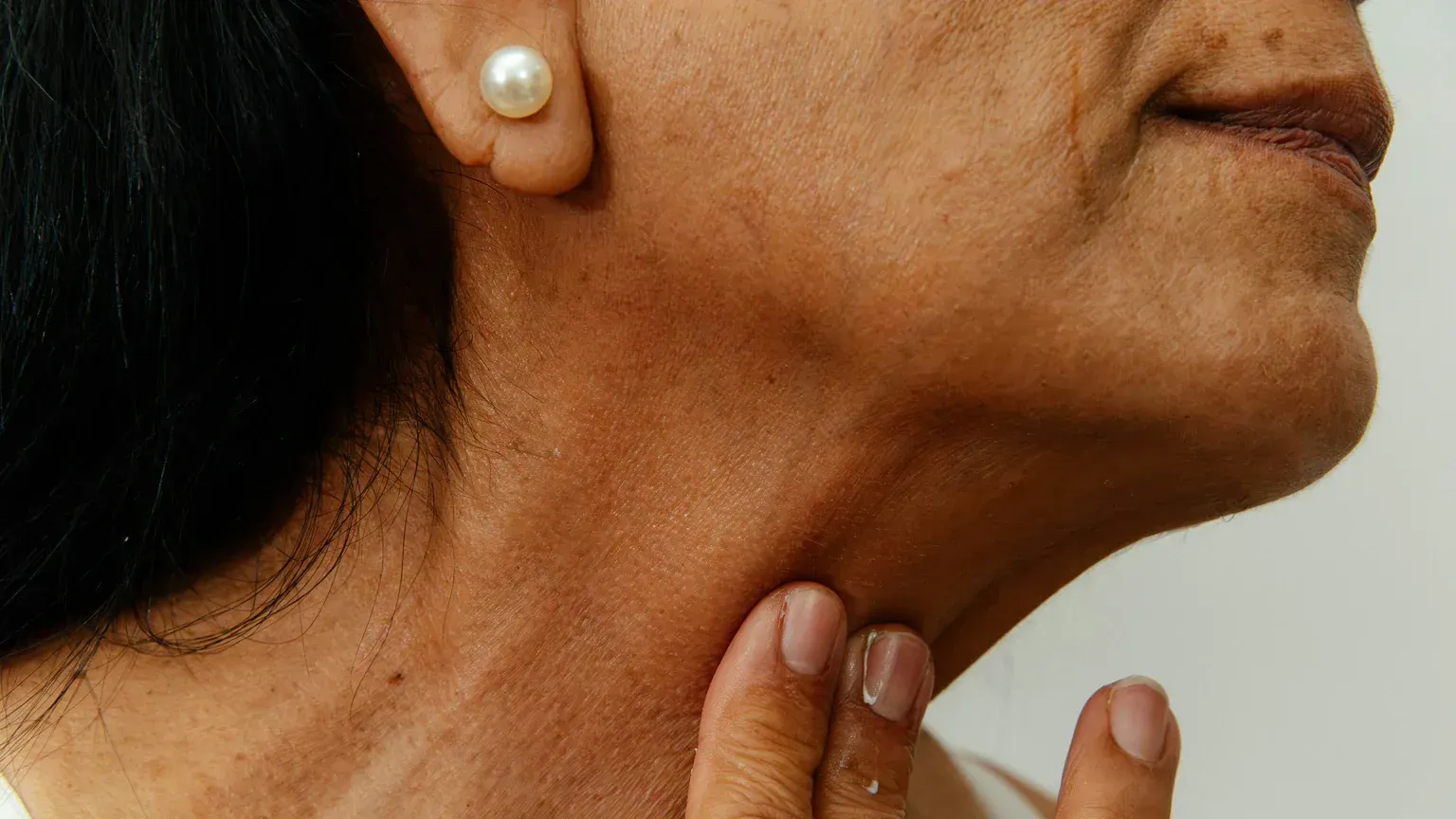 A person checking the pulse at their neck