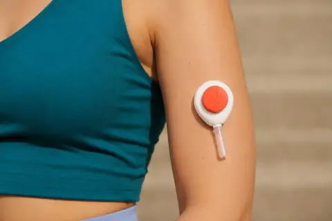 An at-home blood test kit with a Tasso+ collector on a kitchen table